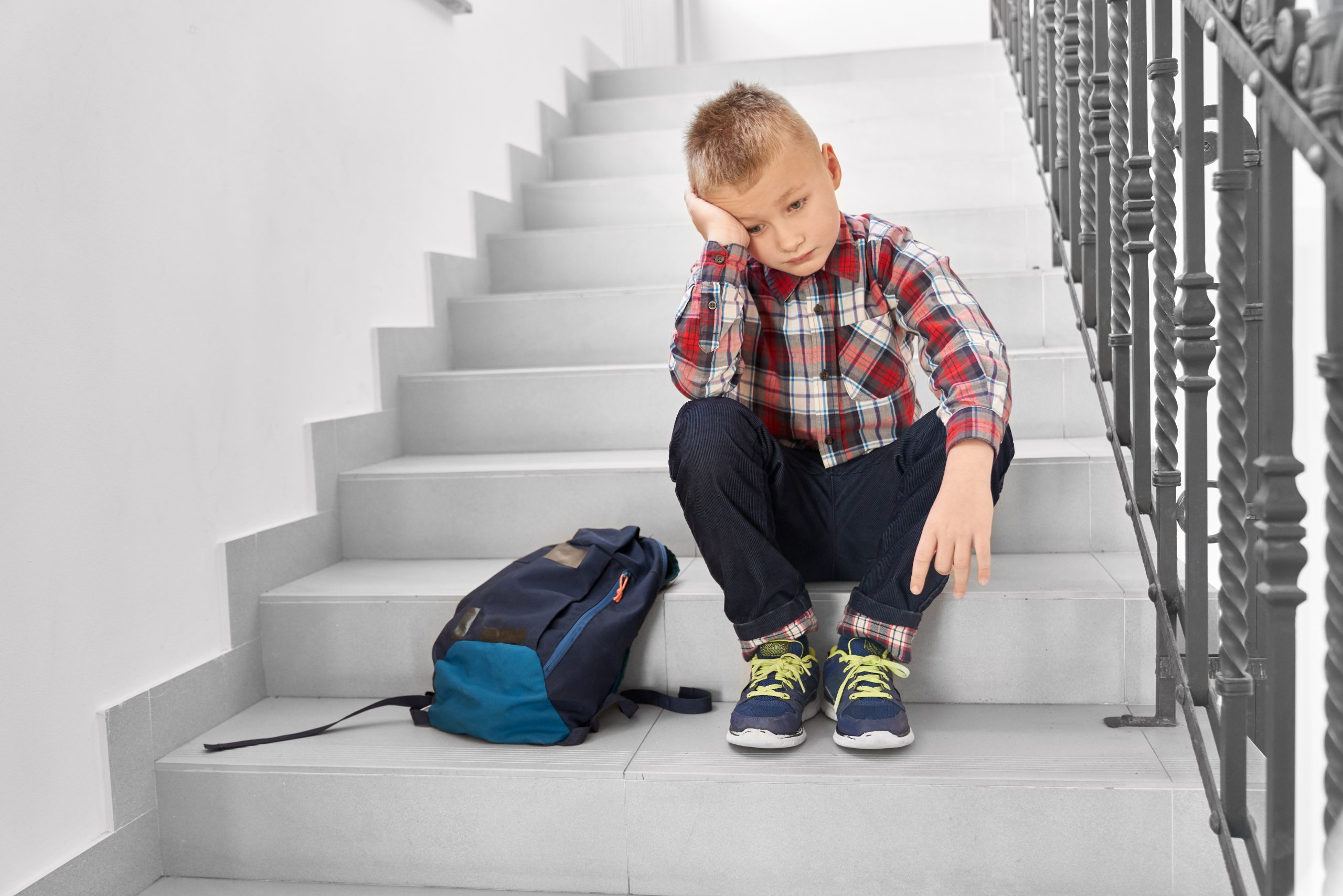 На ступеньку вскакивает хлопчик. Мальчик сидит на лестнице. Ступенька для детей. Лестница для детей. Мальчик на ступеньках.